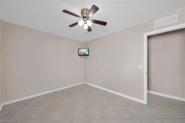 Unfurnished room with a ceiling fan and light tile patterned flooring