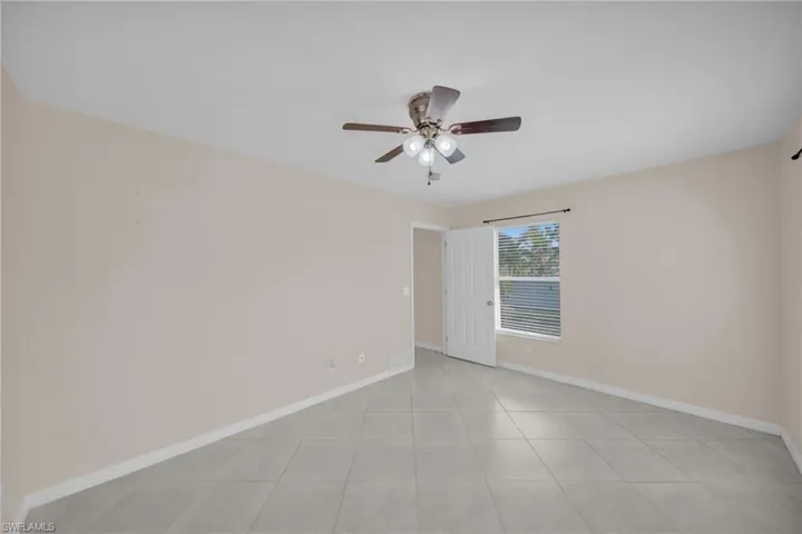 Unfurnished room featuring ceiling fan and light tile patterned floors