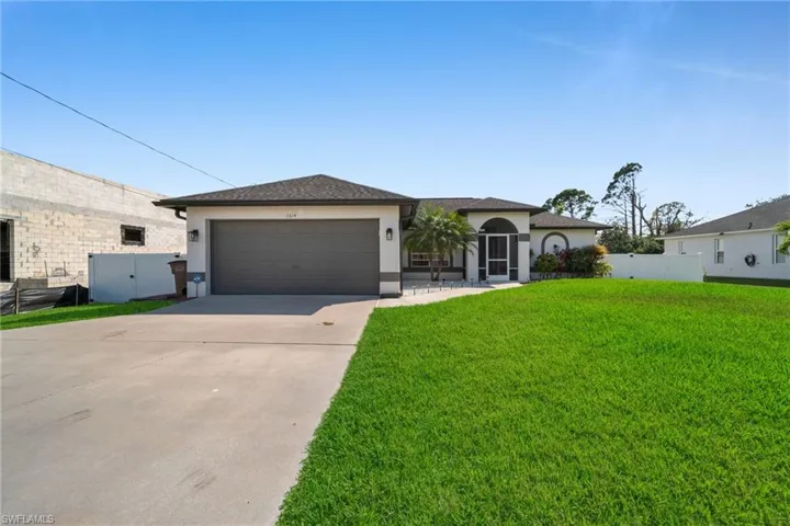 View of front of home with stucco siding, driveway, and an attached garage