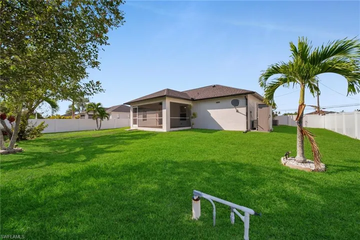 Rear view of property with a fenced backyard, a sunroom, and stucco siding