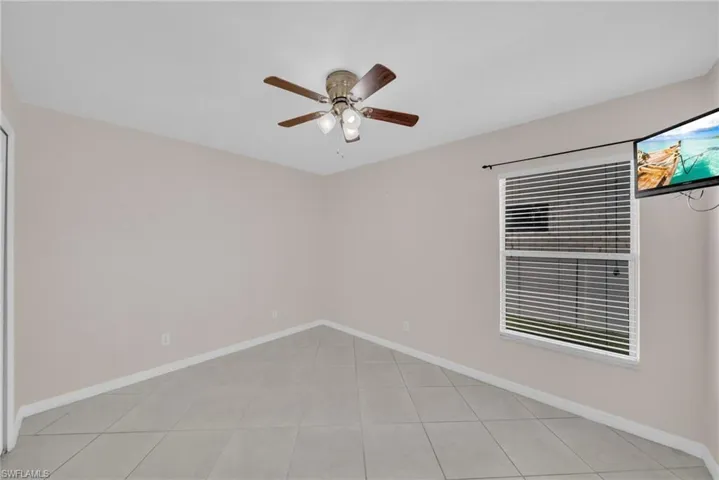 Spare room featuring a ceiling fan and light tile patterned flooring