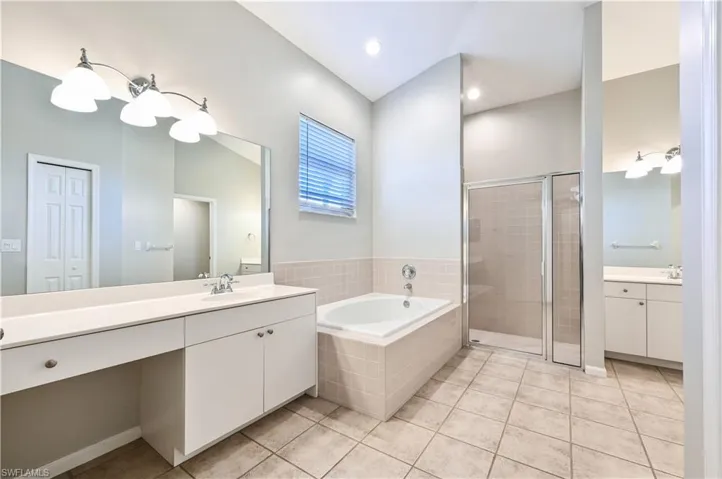 Primary bath with separate sinks, shower, and soaking tub.