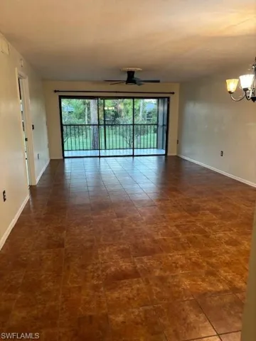 Spare room with plenty of natural light, a ceiling fan, and a chandelier