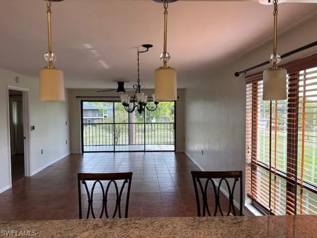 Unfurnished dining area with a chandelier and baseboards