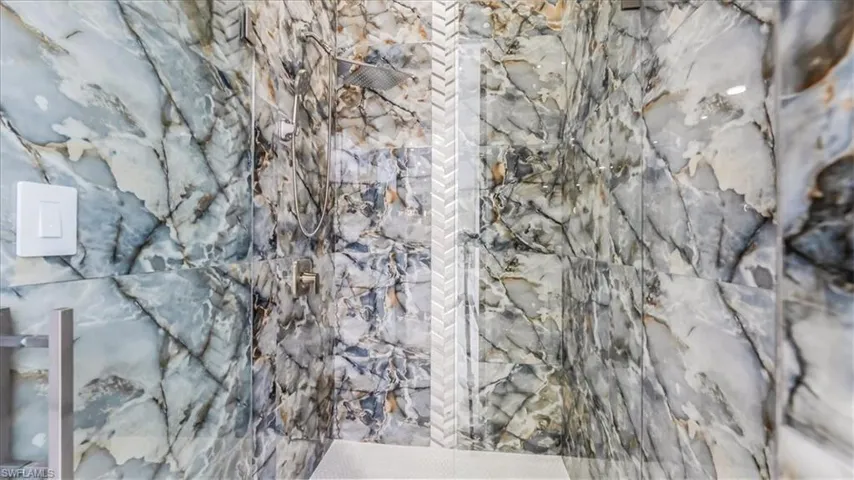 Bathroom featuring a marble finish shower