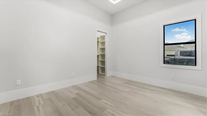 Spare room with light wood-style floors and baseboards