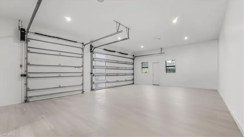 Garage with baseboards and recessed lighting