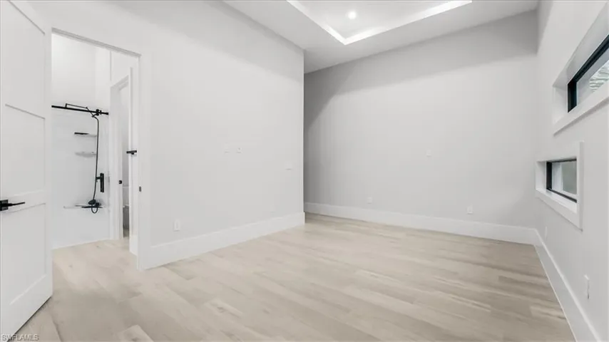 Unfurnished room featuring light wood finished floors and baseboards