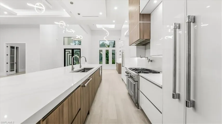 Kitchen with brown cabinetry, modern cabinets, pendant lighting, recessed lighting, and light wood-type flooring