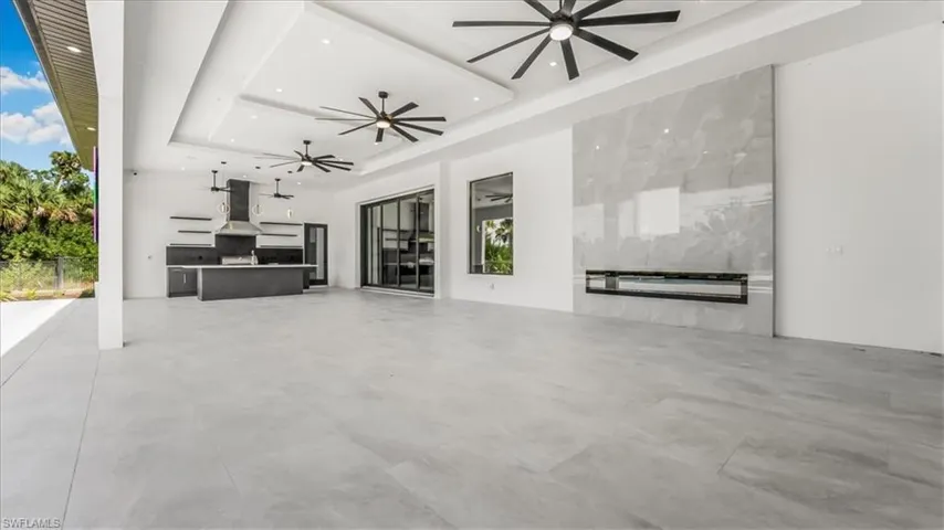 View of patio with area for grilling and ceiling fan