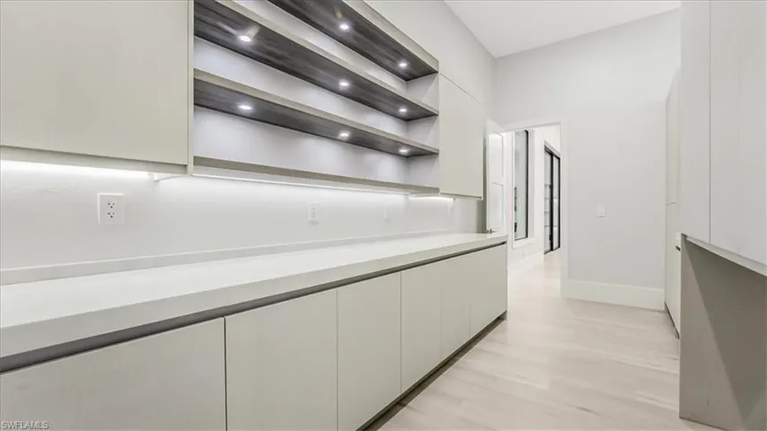 Kitchen featuring open shelves, light countertops, modern cabinets, and light wood-style floors