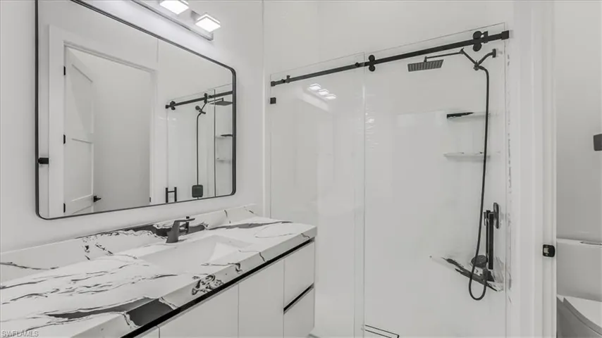 Bathroom with a shower stall and vanity