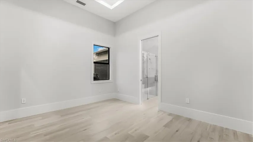 Unfurnished bedroom featuring light wood-style floors and connected bathroom
