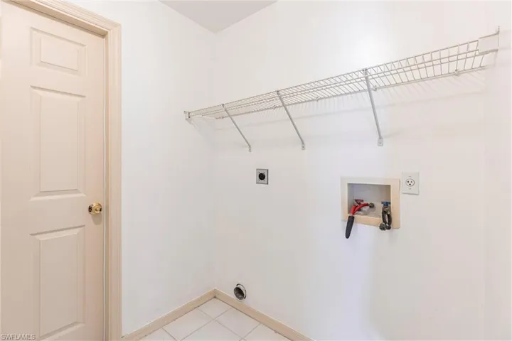 Laundry area featuring hookup for an electric dryer, washer hookup, and light tile patterned floors