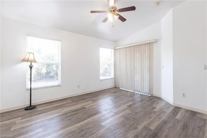 Unfurnished bedroom with vaulted ceiling, wood finished floors, and ceiling fan