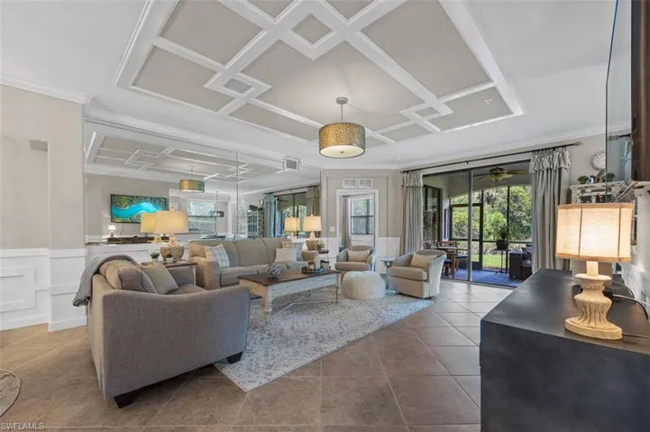 Tiled living room featuring coffered ceiling and ceiling fan