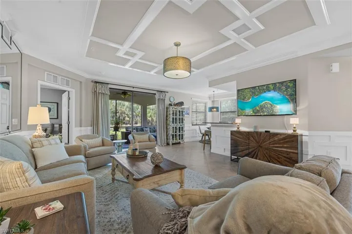 Tiled living room with coffered ceiling and crown molding