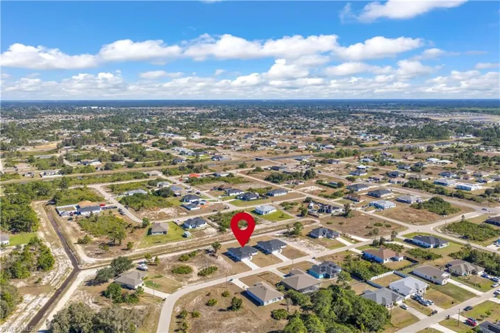 Aerial view of property and surrounding area featuring nearby suburban area