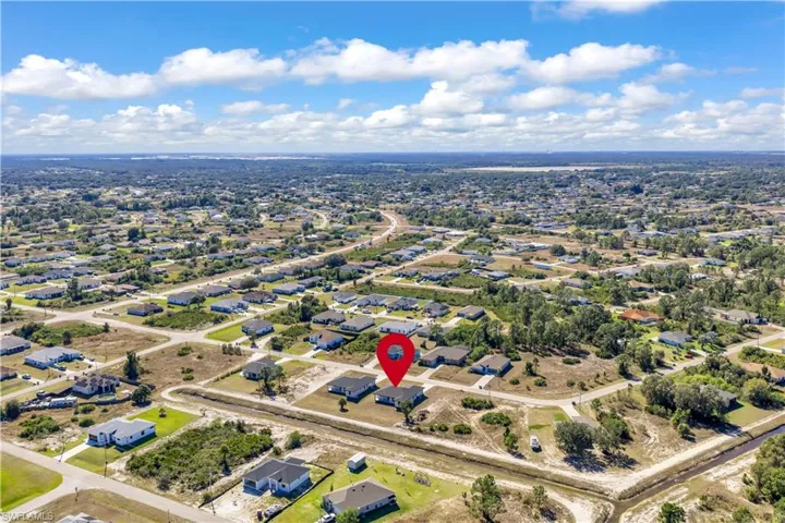 Aerial view of property and surrounding area featuring nearby suburban area