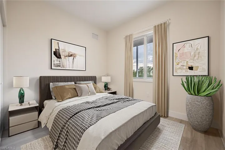 Bedroom with wood finished floors, visible vents, and baseboards