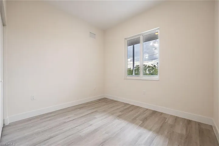 Spare room with visible vents, light wood finished floors, and baseboards
