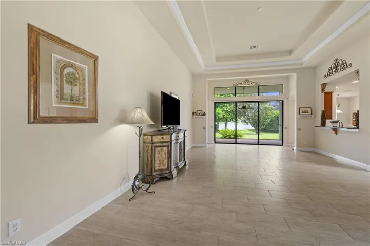 Living room featuring a raised ceiling and light wood-type flooring