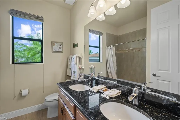Bathroom featuring double vanity and a shower with shower curtain