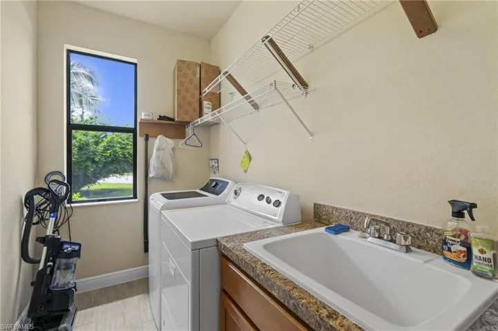 Washroom with a sink and washer and dryer