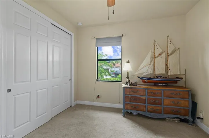 Bedroom featuring light colored carpet, a closet, and ceiling fan
