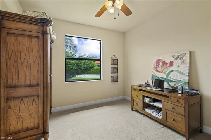 Office space featuring light carpet and a ceiling fan