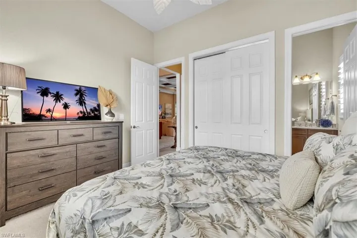 Bedroom with a ceiling fan, a paneled door, and a sliding closet door