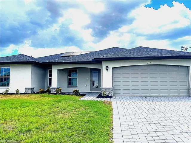 Single story home on a 3-lot site, with 2-car garage, paver driveway and shingle roof.