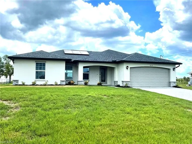 Single story home on a 3-lot site, with 2-car garage, paver driveway and shingle roof.