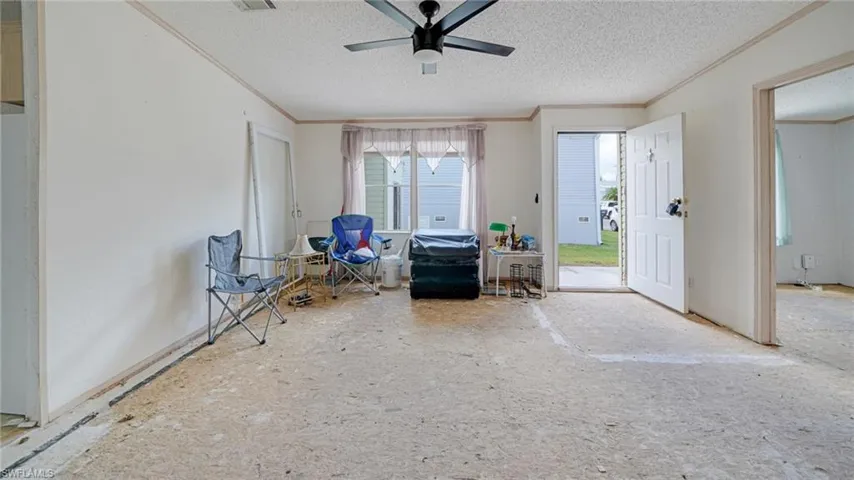 Misc room with ceiling fan, crown molding, and a textured ceiling