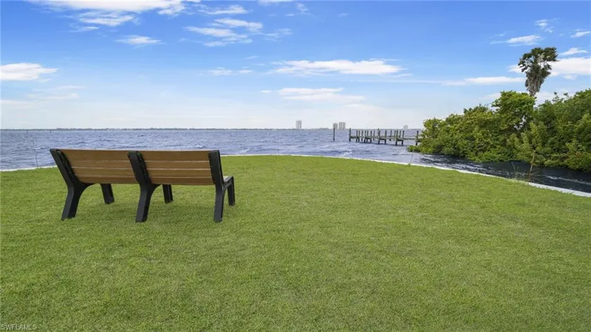 View of home's community with a water view and a yard