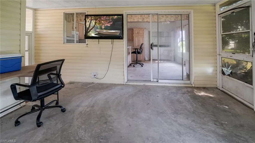 Unfurnished office featuring wooden walls and concrete floors