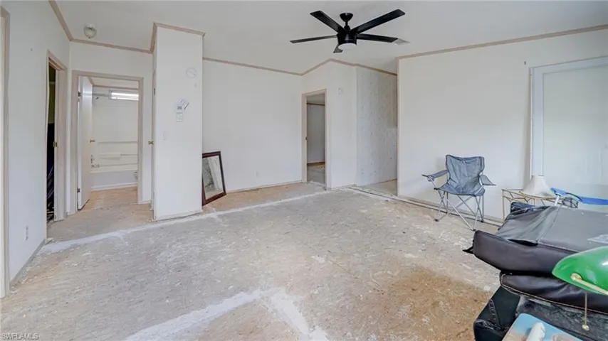 Unfurnished bedroom with crown molding, ceiling fan, and ensuite bathroom