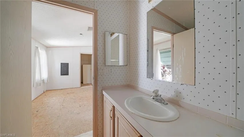 Bathroom featuring crown molding, vanity, and a textured ceiling