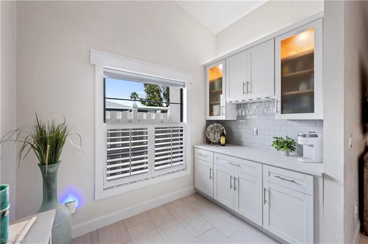 Bulit in Bar Area with Wine Glass holder, Lights, Tile Backsplash, and Quartz Countertop