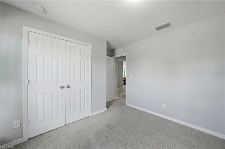 Unfurnished bedroom with carpet and a closet