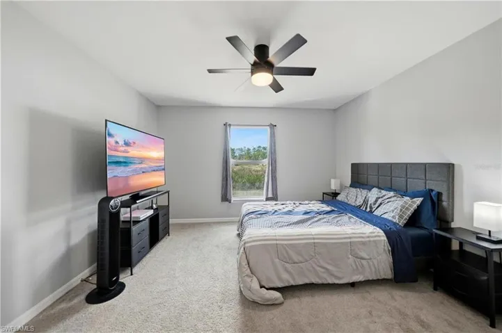 Bedroom featuring light colored carpet and a ceiling fan