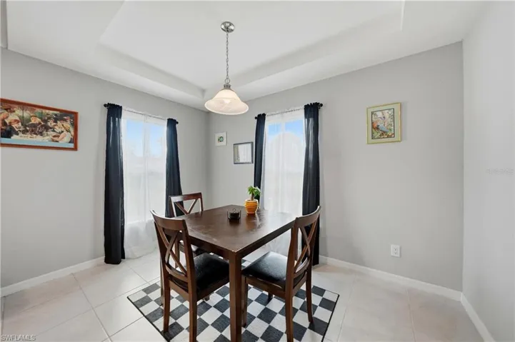 Dining room featuring a raised ceiling and light tile patterned flooring