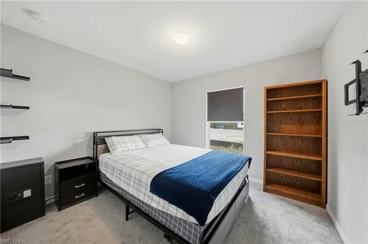 Bedroom with light colored carpet and baseboards