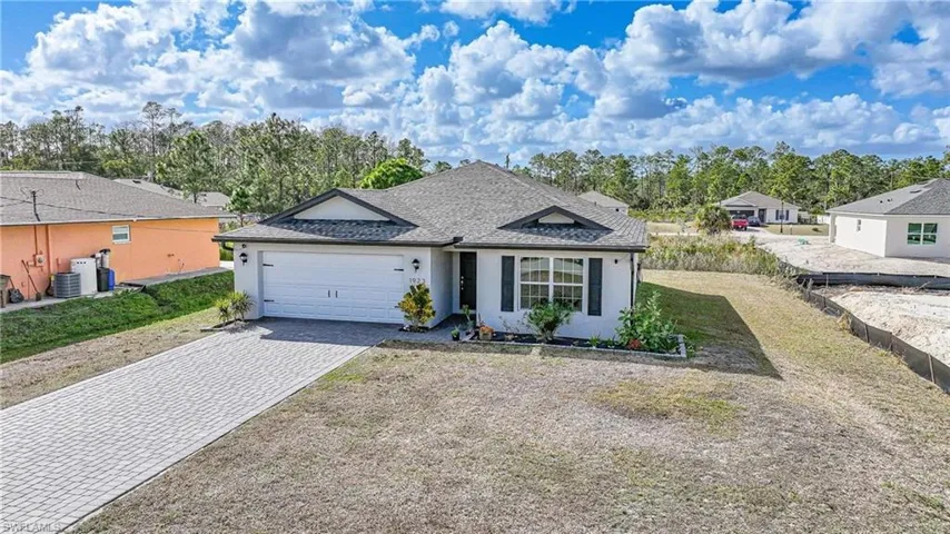 Single story home featuring decorative driveway, a shingled roof, stucco siding, and a garage