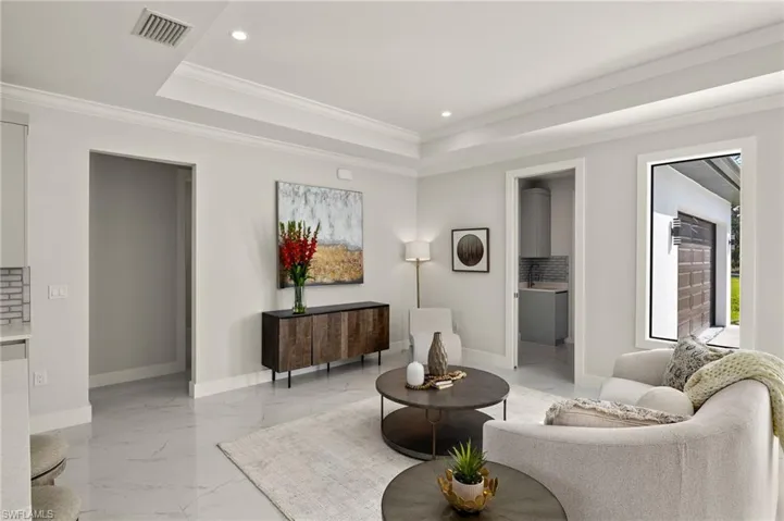 Sitting room featuring recessed lighting, crown molding, light marble finish flooring, and a raised ceiling