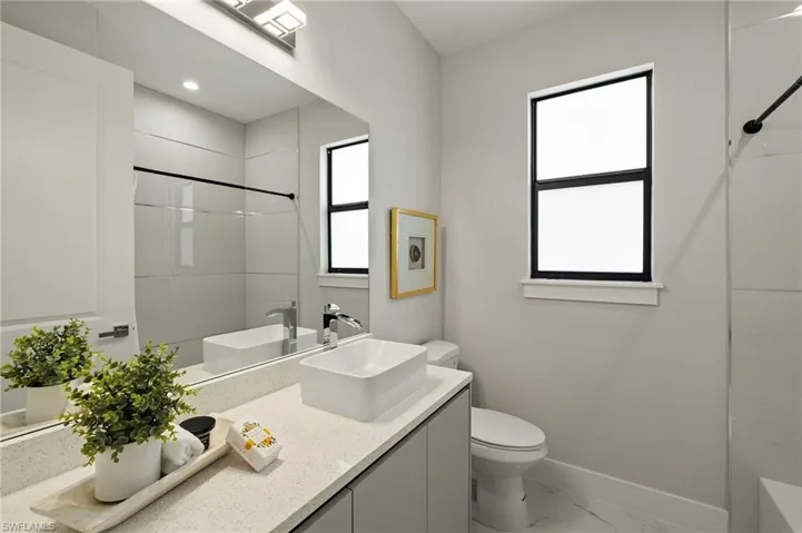 Bathroom with vanity, marble look tile flooring, and bathtub / shower combination