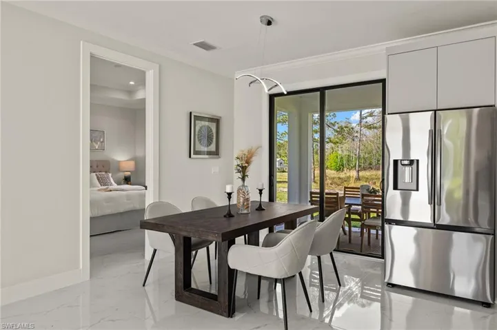 Dining space featuring light marble finish flooring, ornamental molding, and recessed lighting
