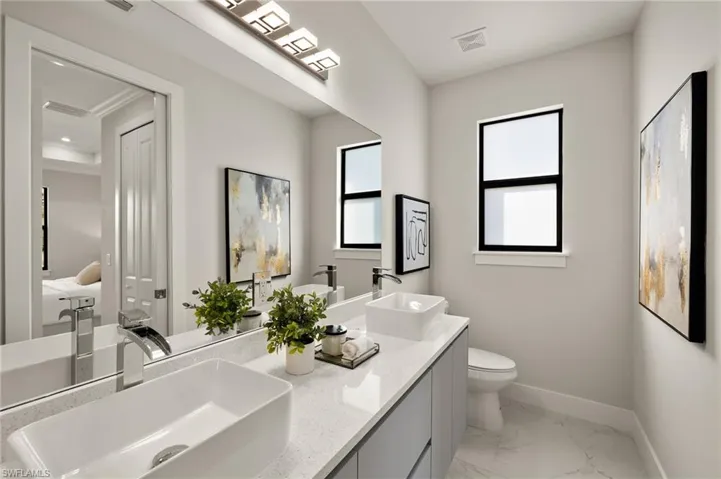 Bathroom with light marble finish flooring and double vanity