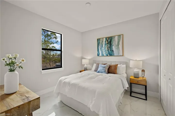 Bedroom with a closet and marble finish floors