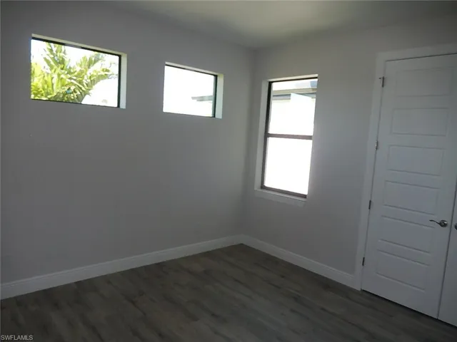 Empty room with baseboards and dark wood finished floors